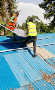 620W Jinko panel being placed on aluminum rails on a roof