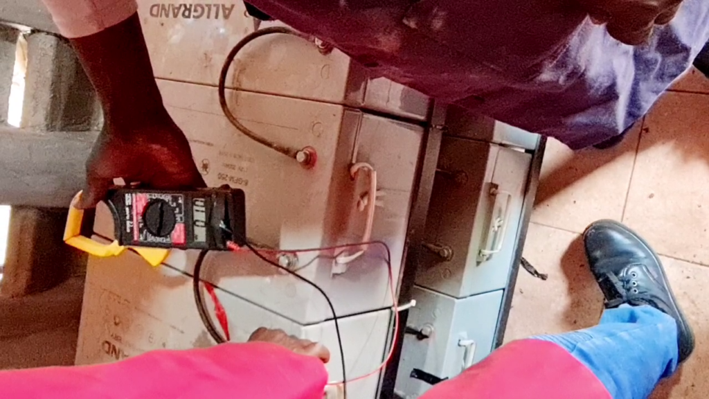 Technician testing solar battery voltage in Kitale Kenya